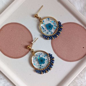 Boucles d'oreilles avec fleurs bleues résinées et tissage perles
