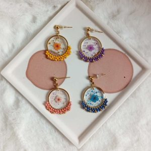 boucles d’oreilles fleur résine et perles et acier inoxydable différentes couleurs Boucles d'oreilles avec fleurs résinées et tissage perles différentes couleurs