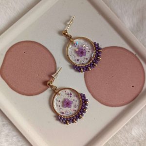 Boucles d'oreilles avec fleurs mauves résinées et tissage perles
