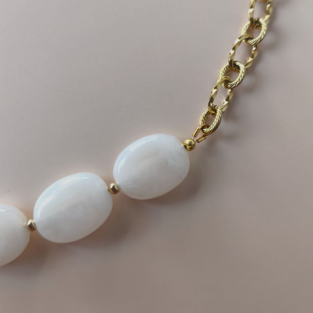 zoom sur le détail de la chaine et des perles marbrées nacre blanc