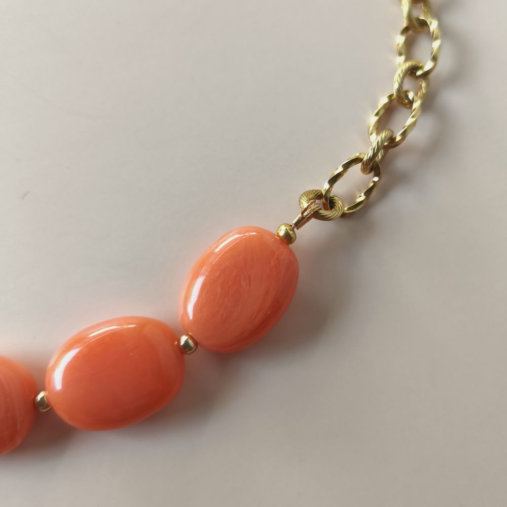 zoom sur le détail de la chaine et des perles marbrées corail
